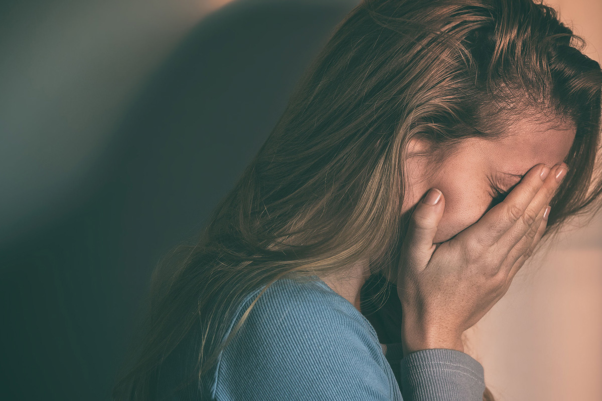 mujer que llora con las manos en su rostro - Mitos sobre el abuso sexual que debemos romper