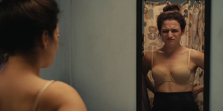 Mujer se mira los senos en el espejo